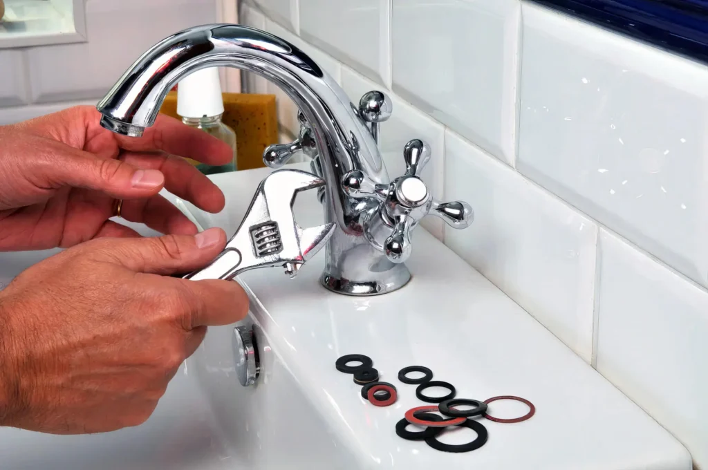 Plumber performing maintenance on a bathroom faucet in Broomfield