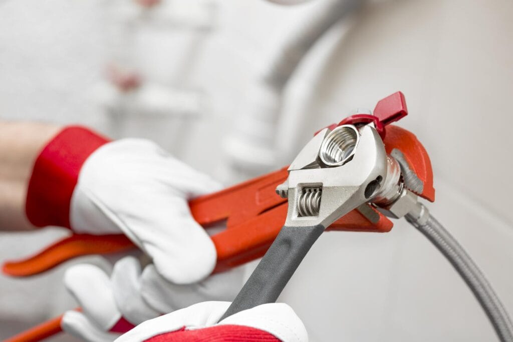 Plumber holding pipe wrenches for an emergency repair in Broomfield