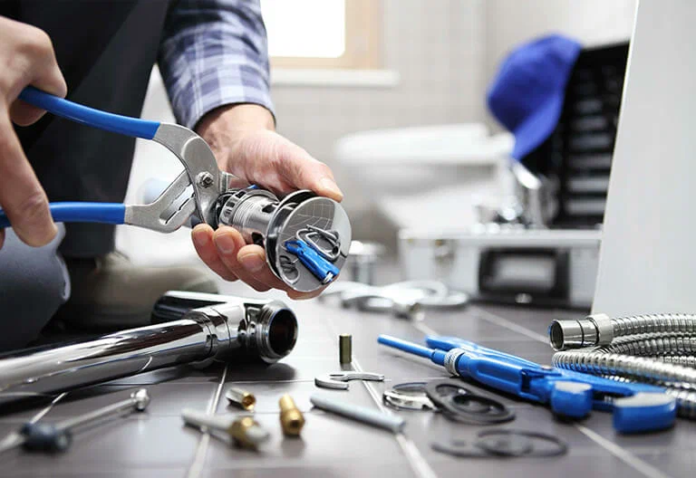 Technician repairing a plumbing fixture with professional tools in Broomfield