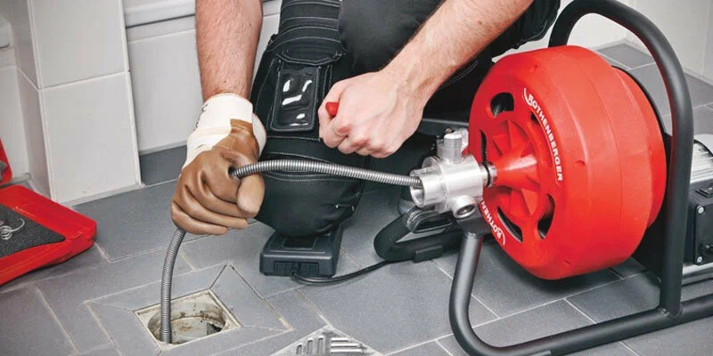 Plumber using a drain-cleaning machine in Broomfield
