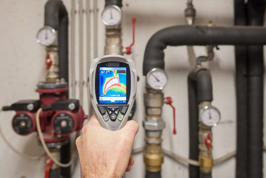 Plumber using a thermal imaging camera to inspect pipes in Broomfield