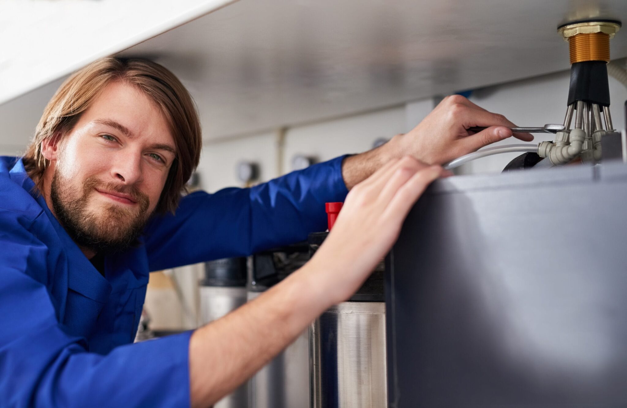 Technician servicing a residential water heater tank in Broomfield